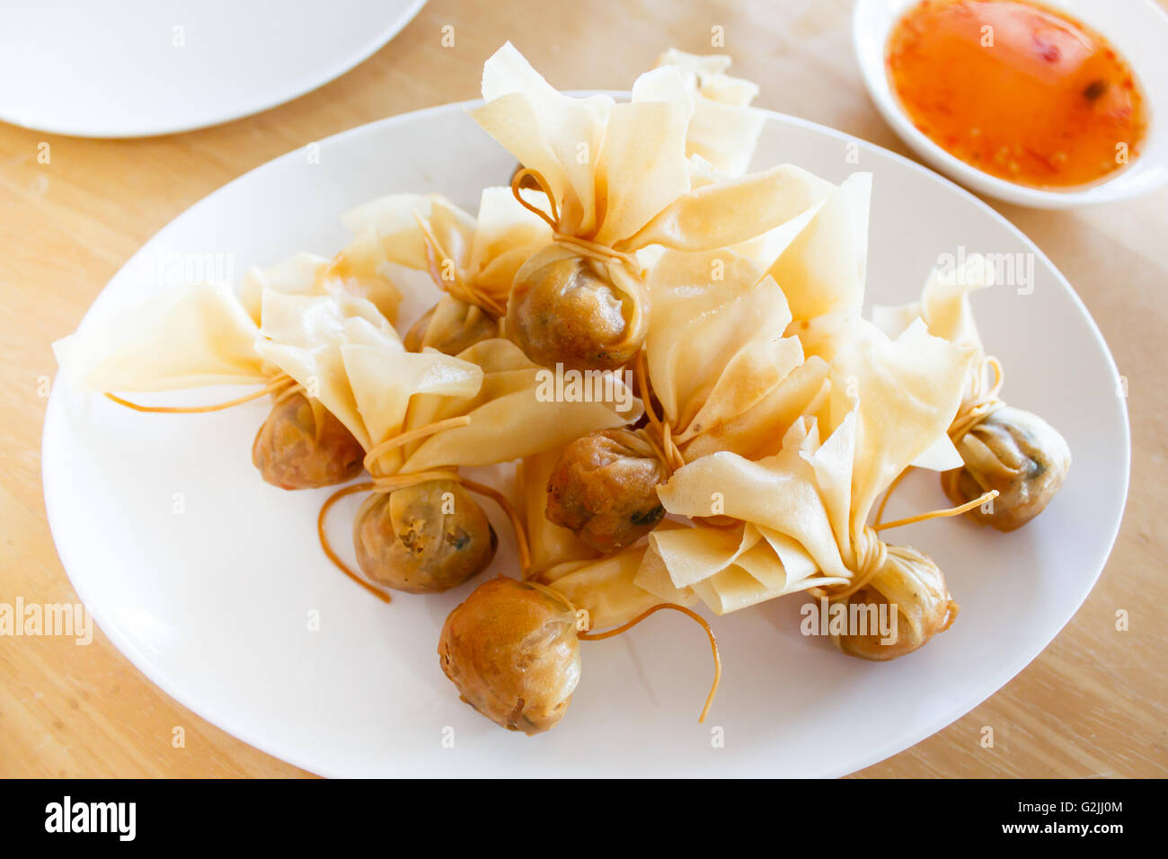 Tailandese tradizionale antipasti (Toong Tong), involtini primavera serviti con salsa al peperoncino dolce. Foto Stock