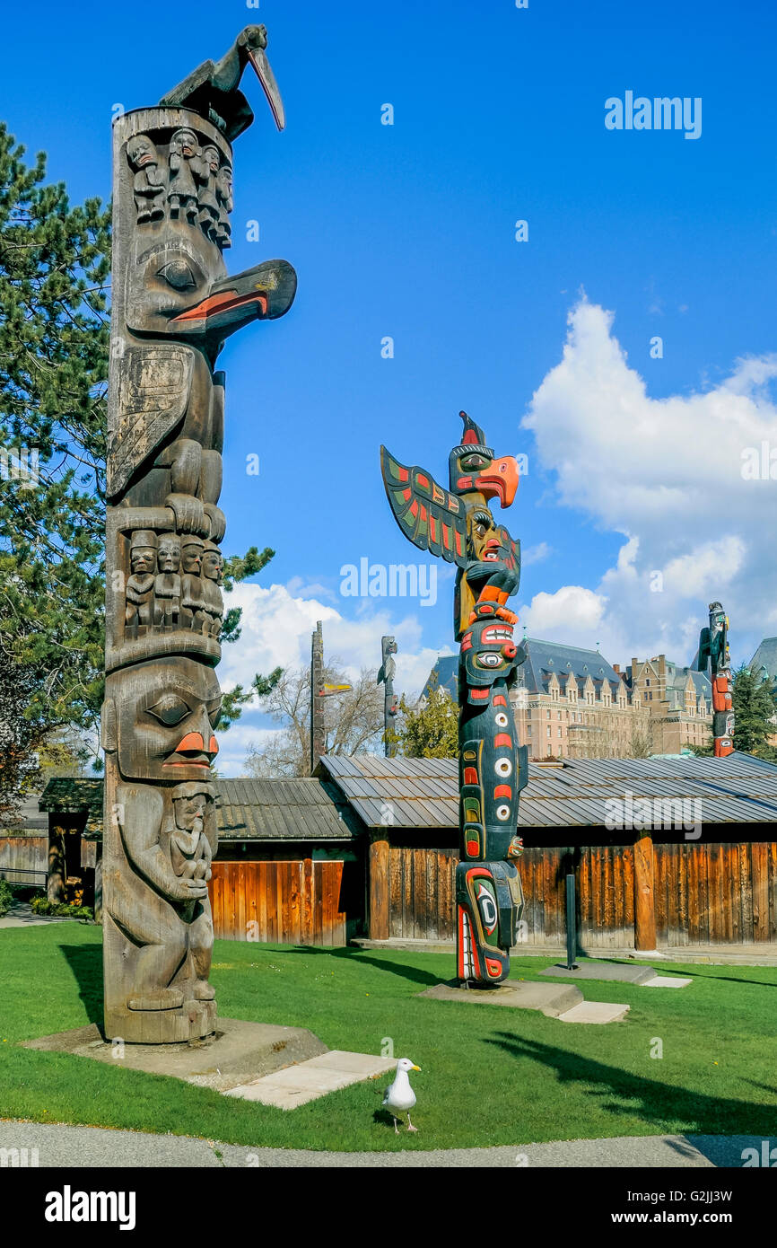 Prima Nazione Totem, Thunderbird Park, accanto al Royal British Columbia Museum, con Empress Hotel in background, Victoria, B Foto Stock