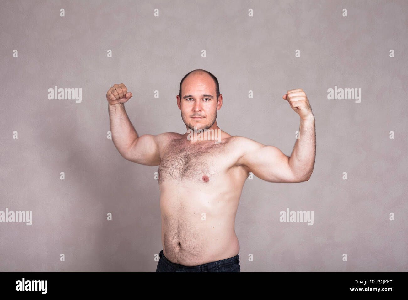 Ritratto di uomo shirtless in posa e mostra le sue forti braccia e corpo peloso. Foto Stock