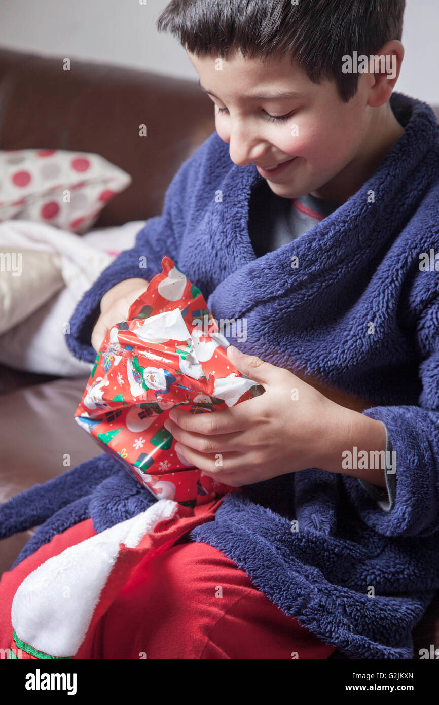 Bambino felice scartare i regali di Natale Foto Stock