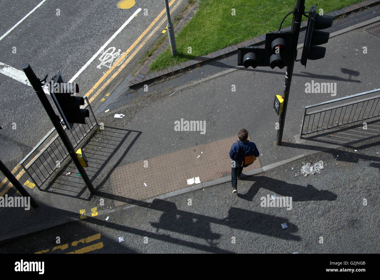 Giovane uomo attraversa road da sopra al semaforo, Glasgow, Scotland, Regno Unito. Foto Stock