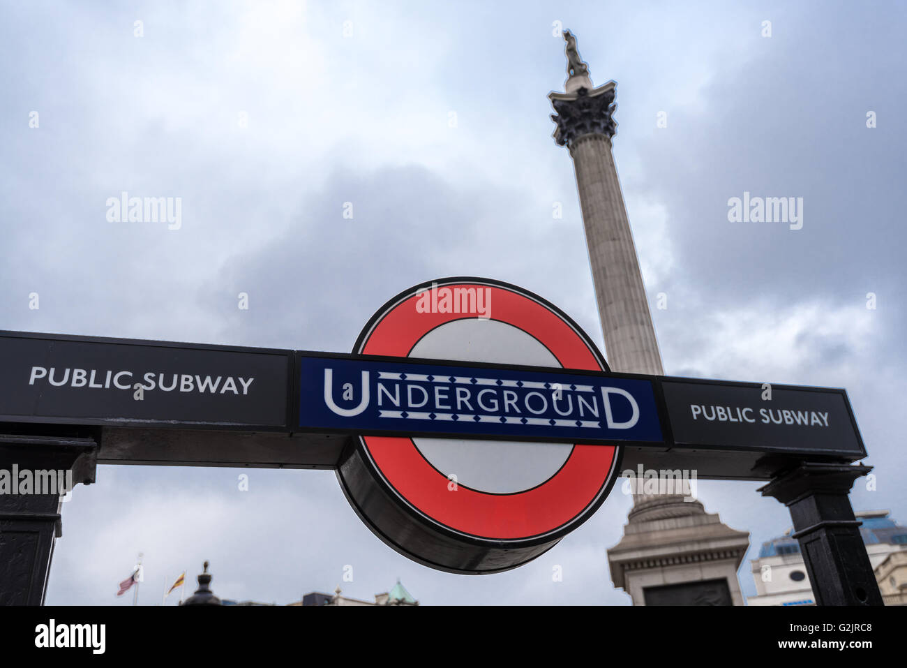 La metropolitana di Londra segno di ingresso e Monumento Nelson in Trafalgar Square Foto Stock
