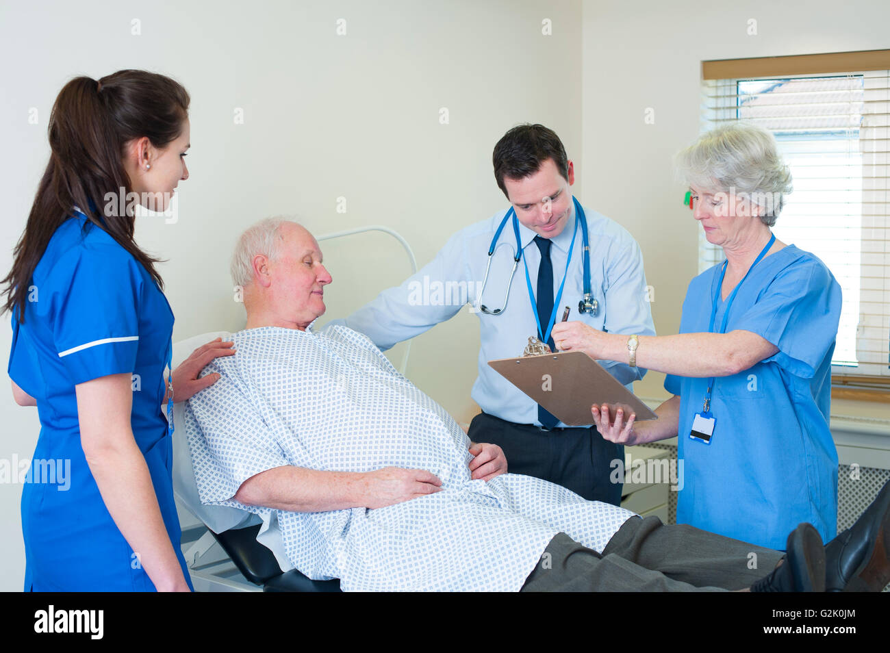 Il team medico di consultare con paziente Foto Stock