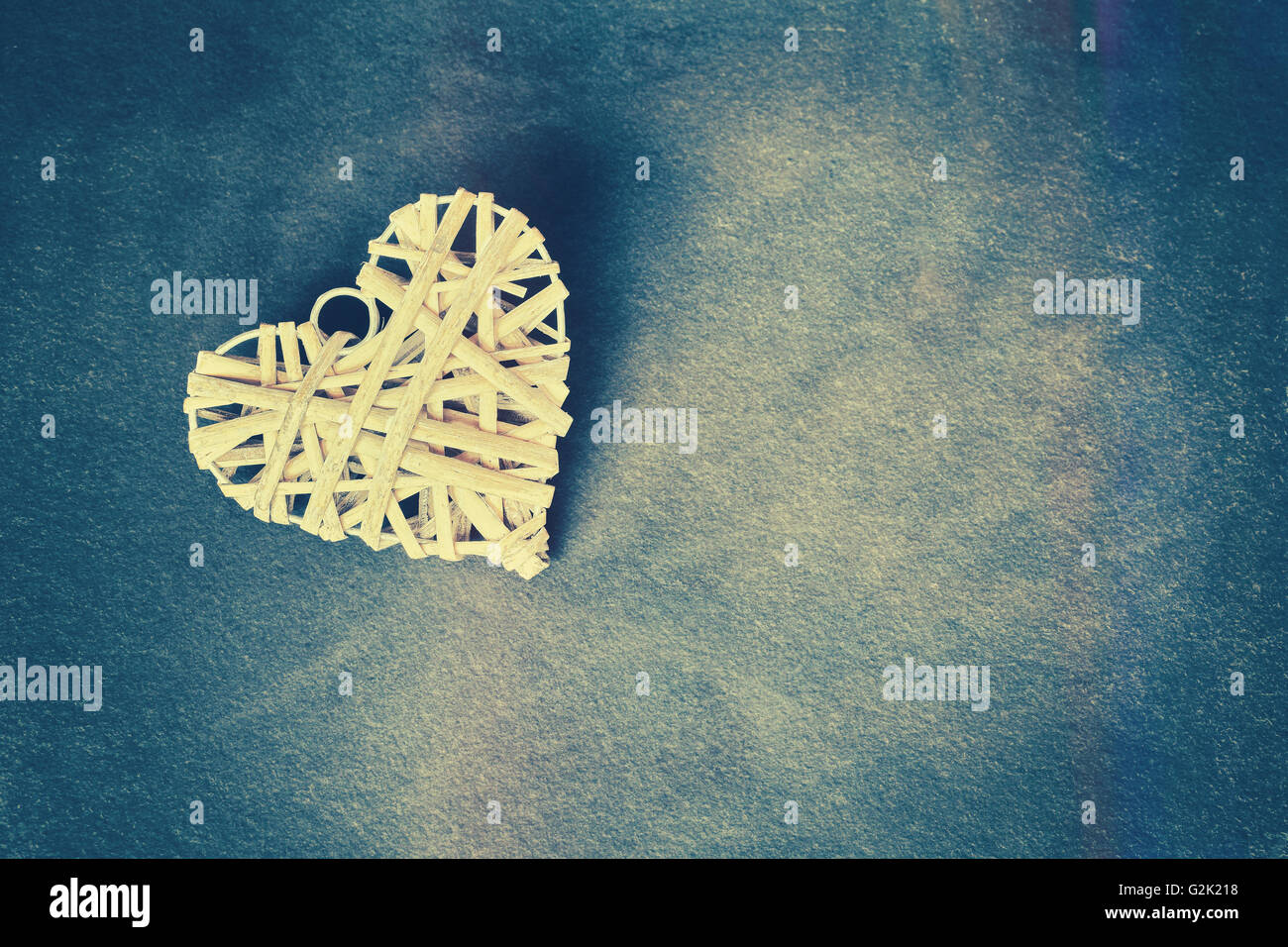 Vintage cuore stilizzato su grunge sfondo di pietra, profondità di campo, spazio per il testo. Foto Stock
