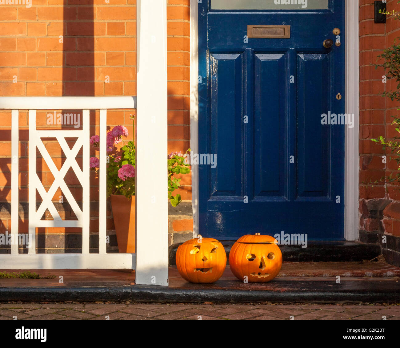 Due zucche con volti scolpiti nel loro davanti alla porta di una casa di Halloween, England, Regno Unito Foto Stock