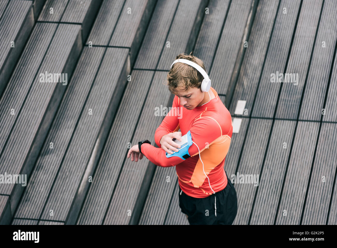 Runner uomo tuning il suo lettore musicale mp3 durante il jogging Foto Stock