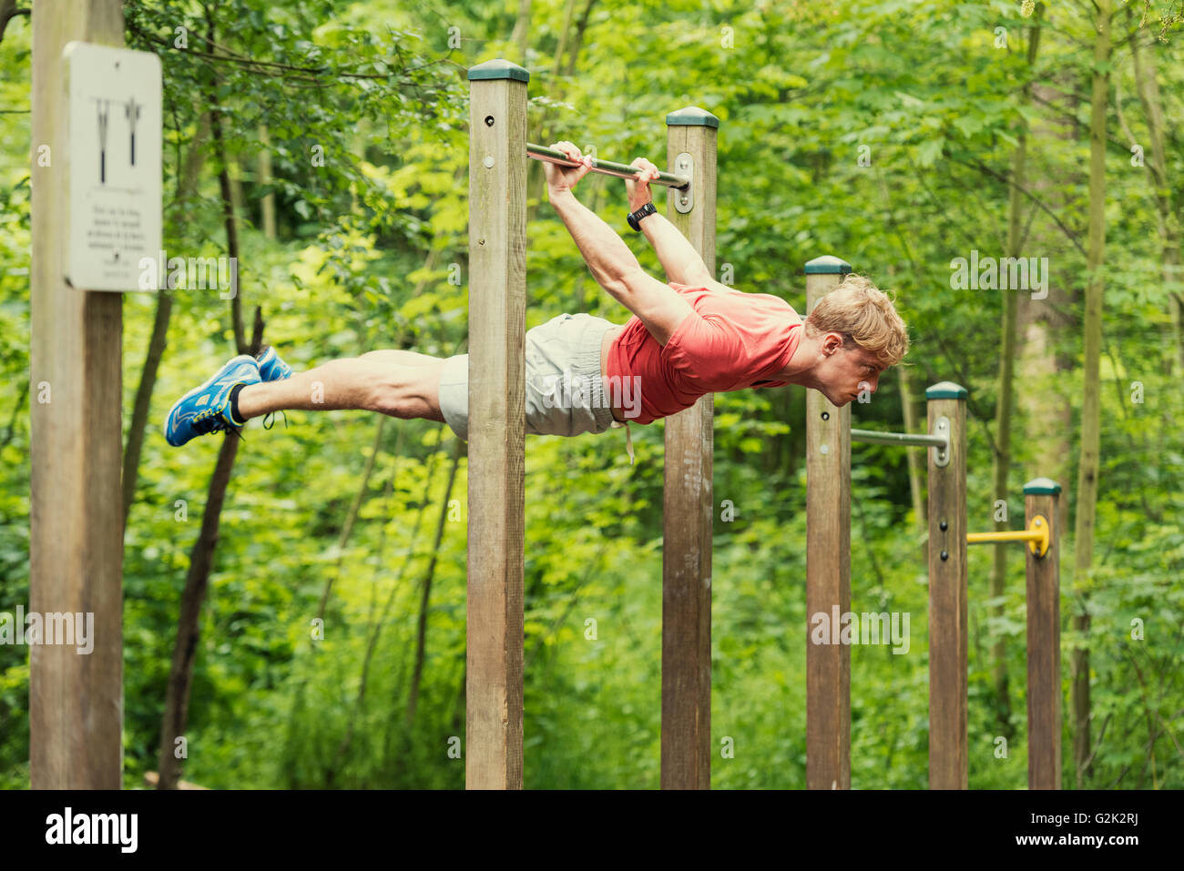 Atleta maschio facendo muscolo-up sulla barra orizzontale Foto Stock