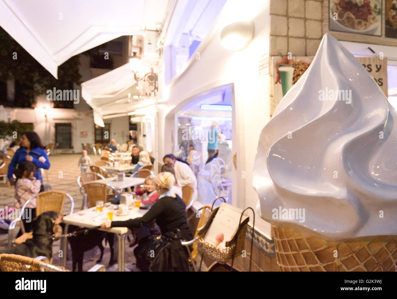 La gente a mangiare il gelato in una gelateria, Estepona, Andalusia, Spagna Foto Stock