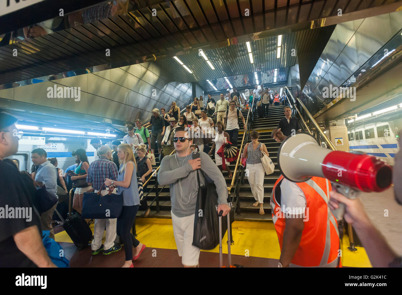 Migliaia di scendere a bordo della palla di cannone alla Stazione Penn di New York di uscire dalla città per il weekend del Memorial Day Venerdì 27 Maggio, 2016. Ogni venerdì durante il periodo estivo il treno, consistente di double-decker cars tirato da un potente dual-mode locomotiva, correrà express per Westhampton sull'Isola Lunga rendendo le 76 miglia di viaggio in 94 minuti. Da Westhampton continuerà a punti a est che arrivano in corrispondenza della punta dell'isola, Montauk. La domenica il treno procederà in retromarcia e tornare alla stazione di Penn. Il treno è il solo nome eseguito su ferrovia. Il viaggio da Penn Station a Montauk ter Foto Stock