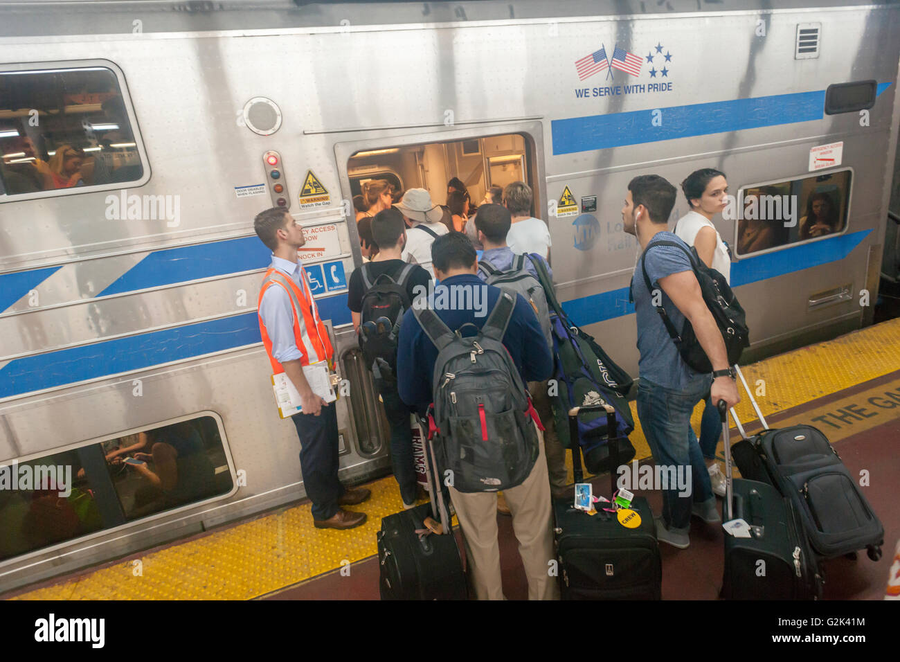 Migliaia pack la palla di cannone alla Stazione Penn di New York di uscire dalla città per il weekend del Memorial Day Venerdì 27 Maggio, 2016. Ogni venerdì durante il periodo estivo il treno, consistente di double-decker cars tirato da un potente dual-mode locomotiva, correrà express per Westhampton sull'Isola Lunga rendendo le 76 miglia di viaggio in 94 minuti. Da Westhampton continuerà a punti a est che arrivano in corrispondenza della punta dell'isola, Montauk. La domenica il treno procederà in retromarcia e tornare alla stazione di Penn. Il treno è il solo nome eseguito su ferrovia. Il viaggio da Penn Station a Montauk terminale è 117 Foto Stock