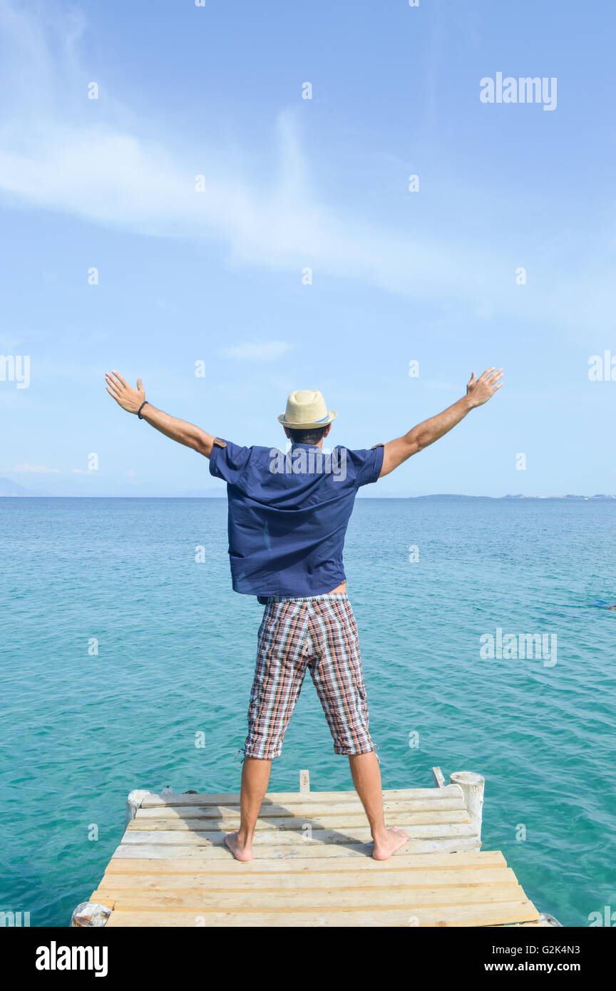 Uomo in piedi su un dock in riva al mare Foto Stock