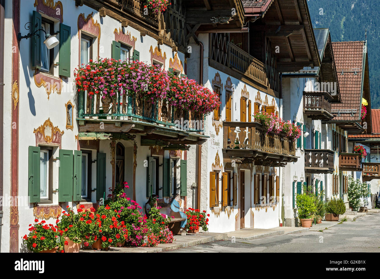 Fila di case coloniche con adornata con gerani (Pelargonium), Sun Street, Garmisch, Garmisch-Partenkirchen District Foto Stock