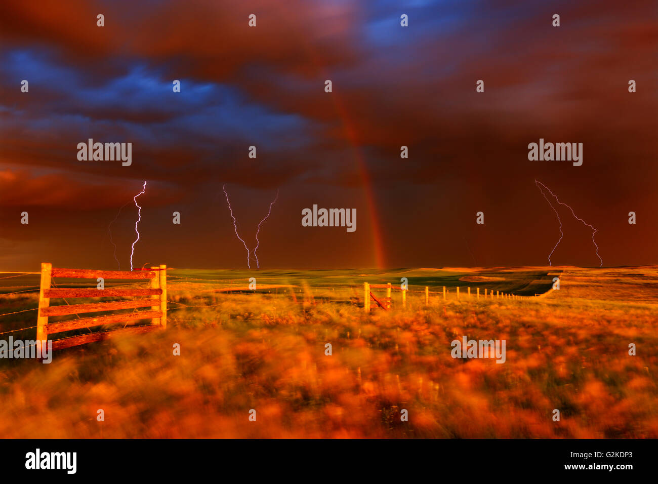 Un fulmine rainbow e regolazione del sole durante la tempesta della prateria. Blocco West praterie Parco Nazionale Saskacthewan Canada Foto Stock