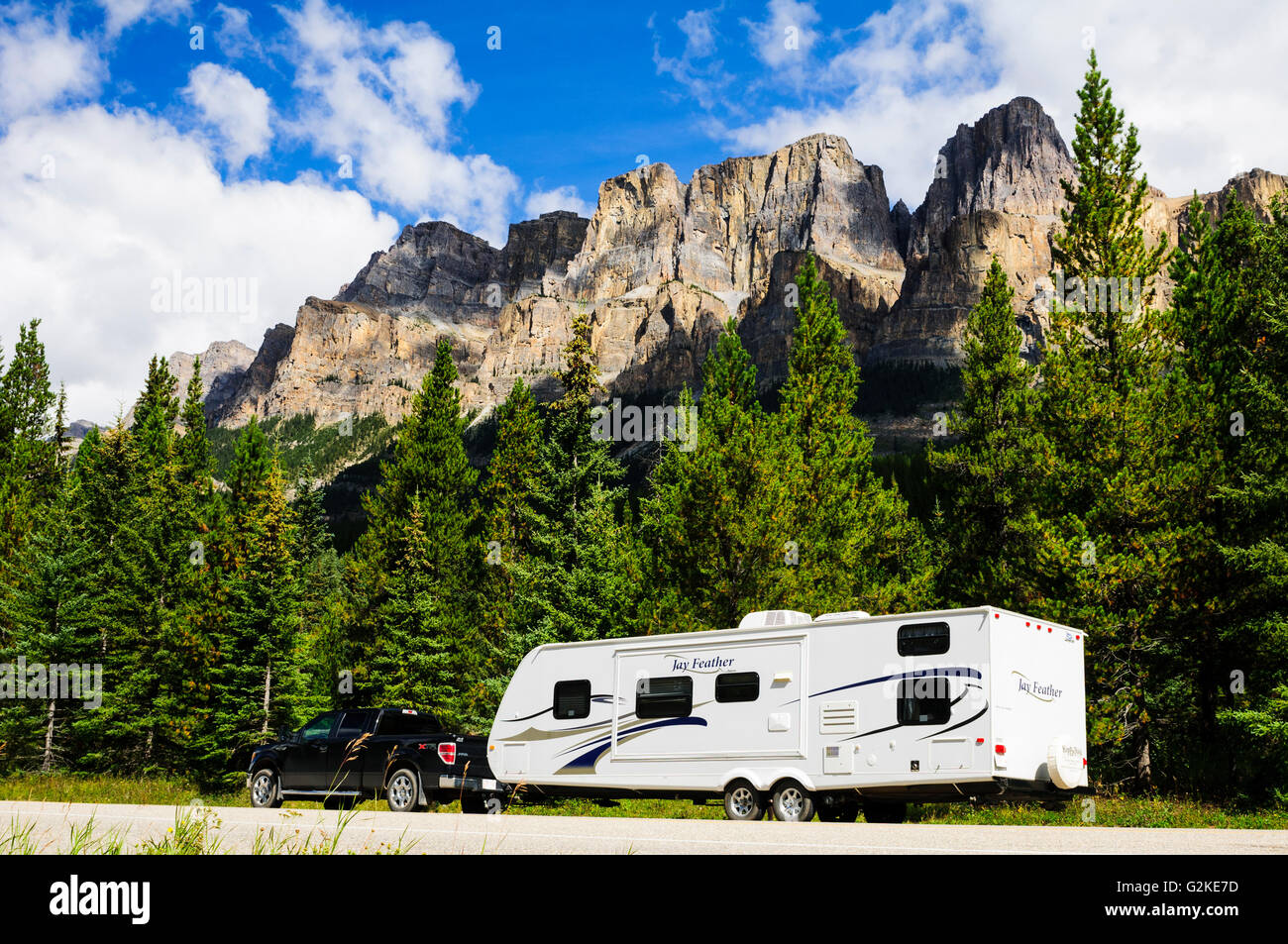 Un camion e rimorchio parcheggiato lungo il Bow Valley Parkway vicino a Banff, Alberta. Castle Mountain è in background. Foto Stock