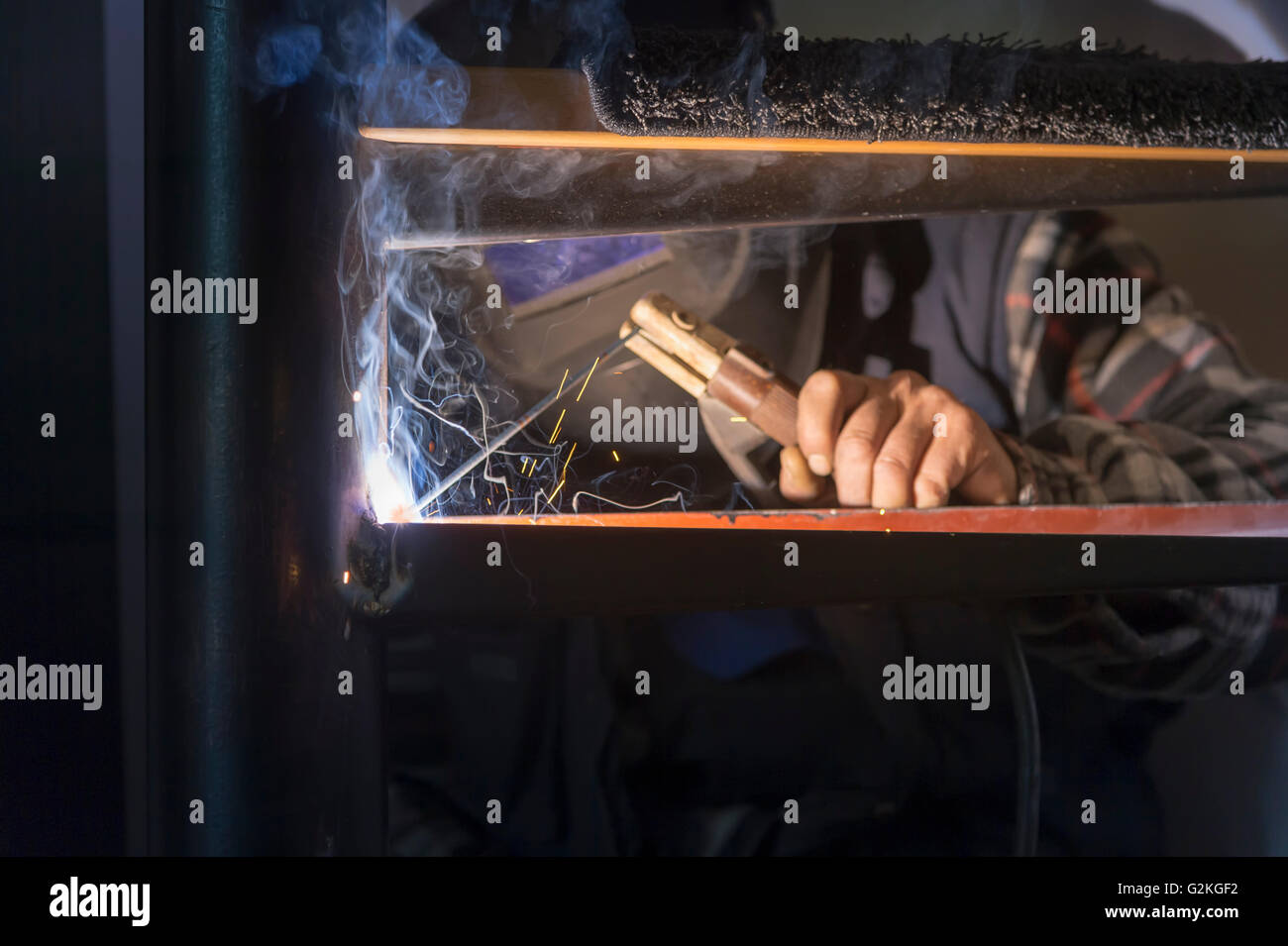 Uomo al lavoro su una scalinata a spirale con torcia elettrica Foto Stock