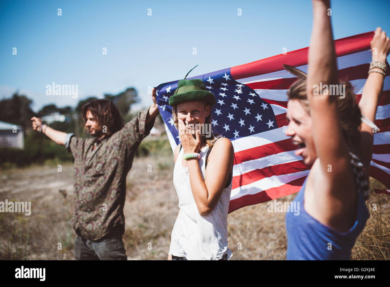Tre carefree hippies con noi bandiera nella natura Foto Stock