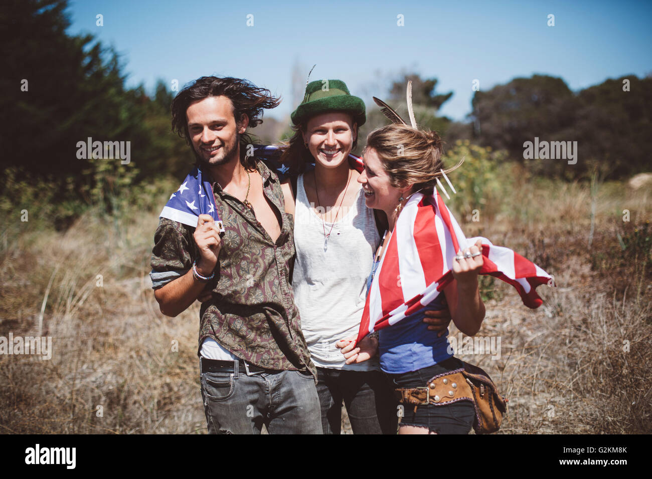 Tre hippies con noi bandiera nella natura Foto Stock