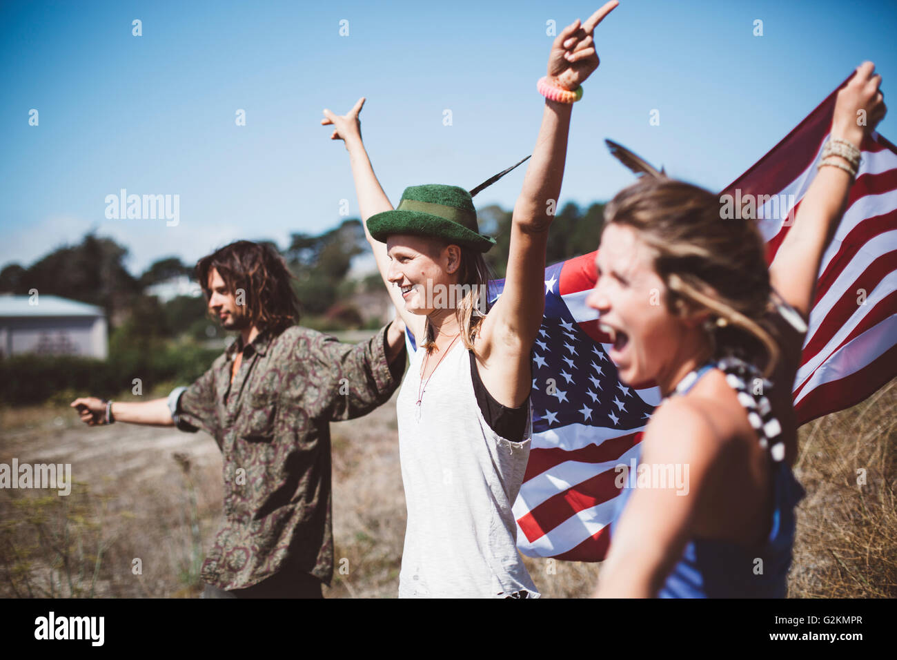 Tre tifo hippies con noi bandiera nella natura Foto Stock