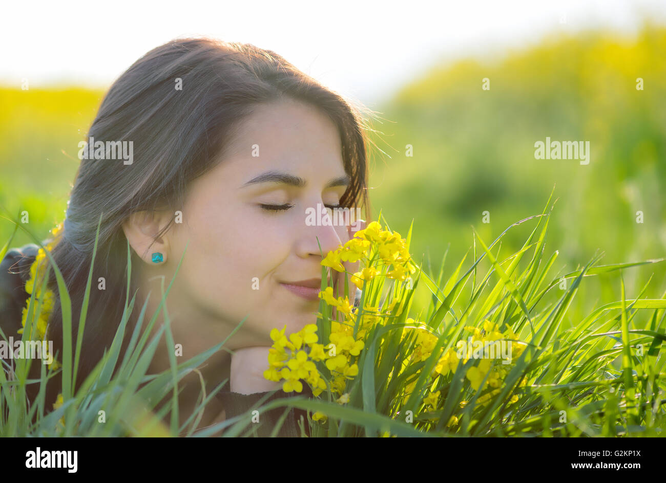 Ritratto di giovane e bella con i capelli lunghi donna giaceva nel parco e profumati fiori Foto Stock