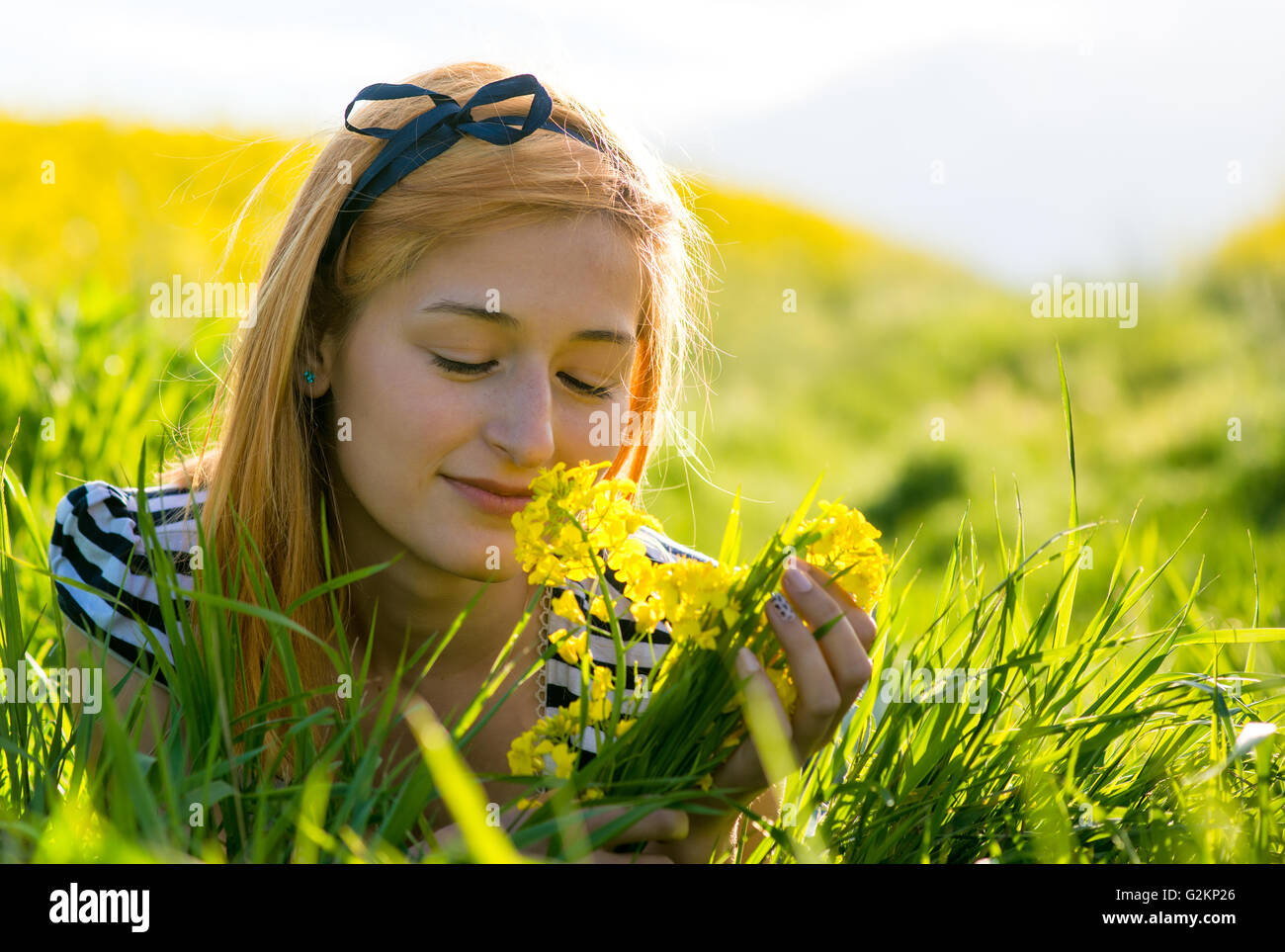Ritratto di giovane e bella con i capelli lunghi donna giaceva nel parco e profumati fiori Foto Stock