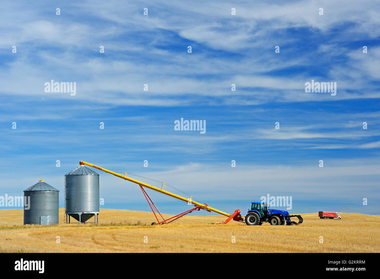 Contenitori del cereale, il trattore e la coclea vicino Beechy Saskatchewan Canada Foto Stock