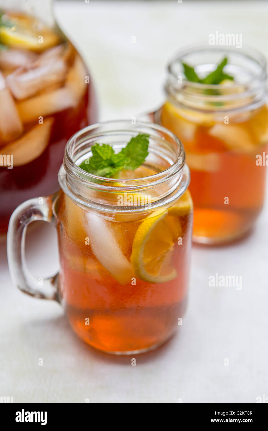 Tè freddo in bicchieri di vetro con limone e menta Foto Stock