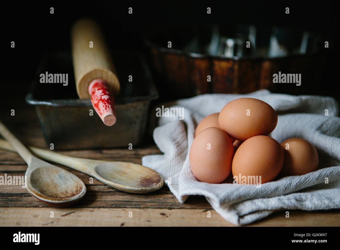 Uova di colore marrone con il cucchiaio di legno, Teglie e rullo Foto Stock