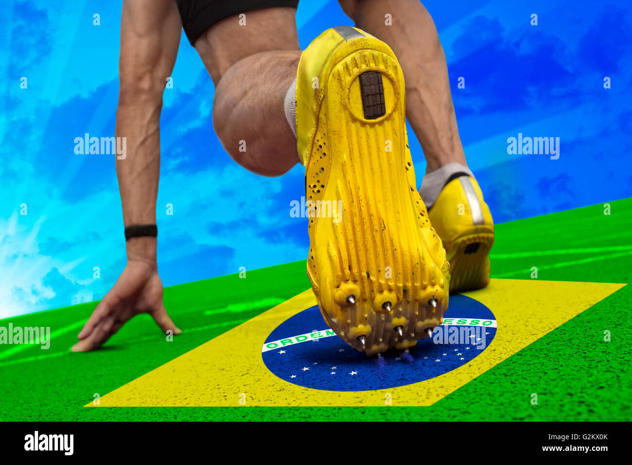 Runner è pronto per iniziare a sulla superficie di tartan con banner brasiliano. Foto Stock