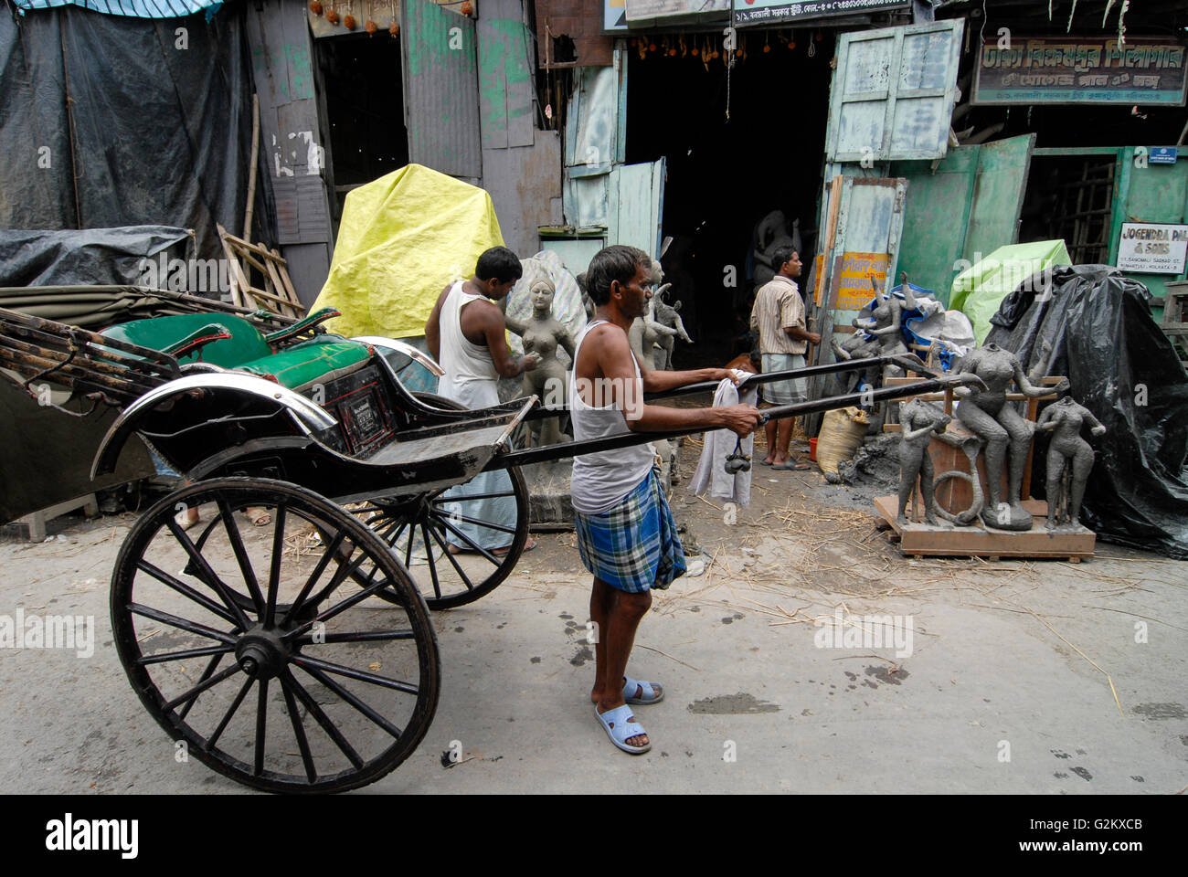 INDIA Westbengal Calcutta Kolkata, sobborgo Kumartuli, scultore forma idoli di argilla di divinità Indù per le feste religiose in bottega artigiana, uomo-powered rickshaw Foto Stock