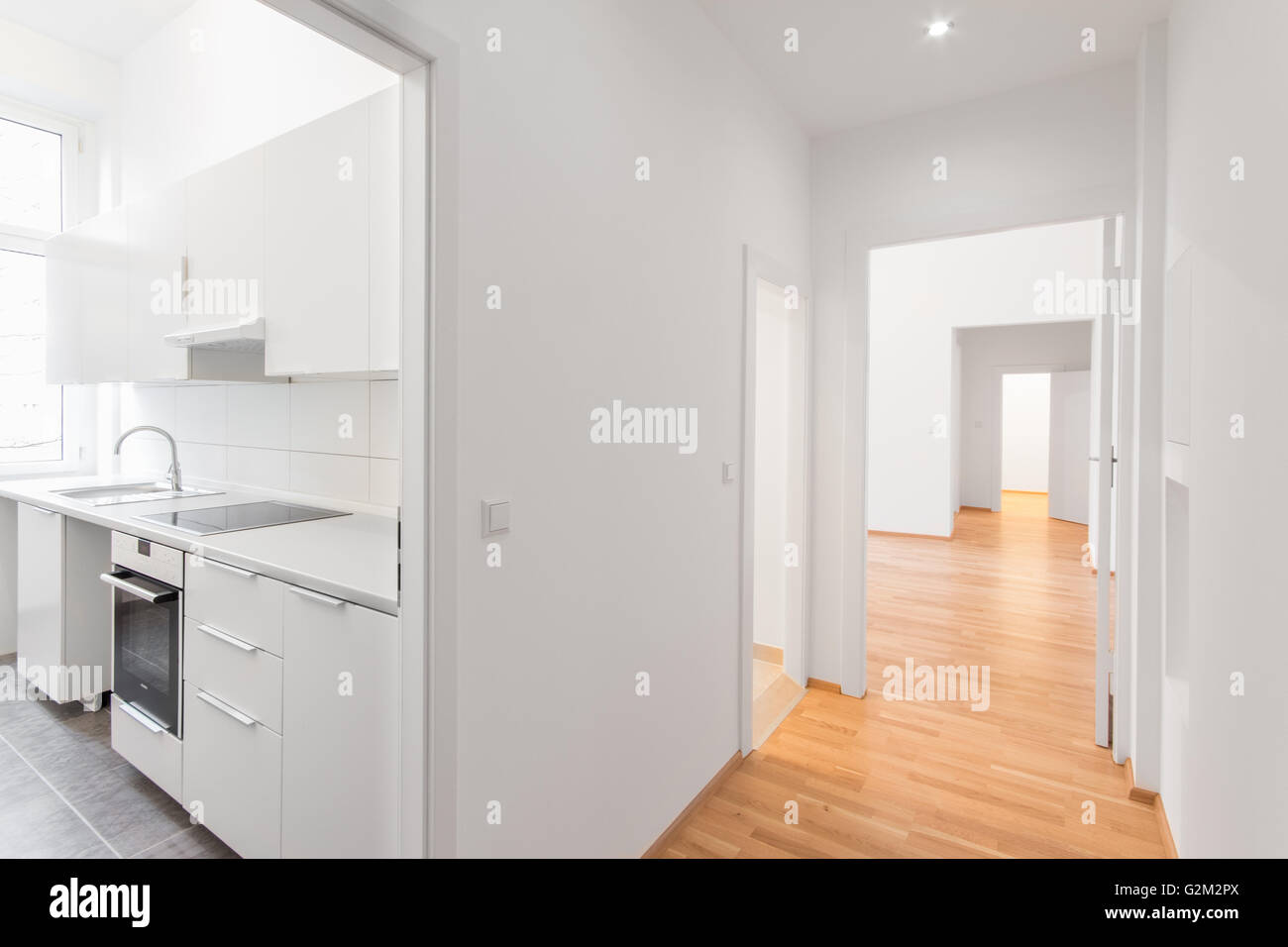 Piatto vuoto , cucina bianca e pavimento in legno Foto Stock