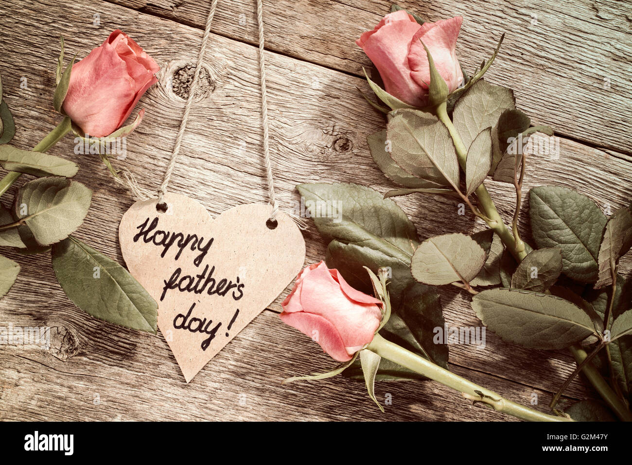 A forma di cuore la festa del papà card con rose rosse su sfondo di legno Foto Stock