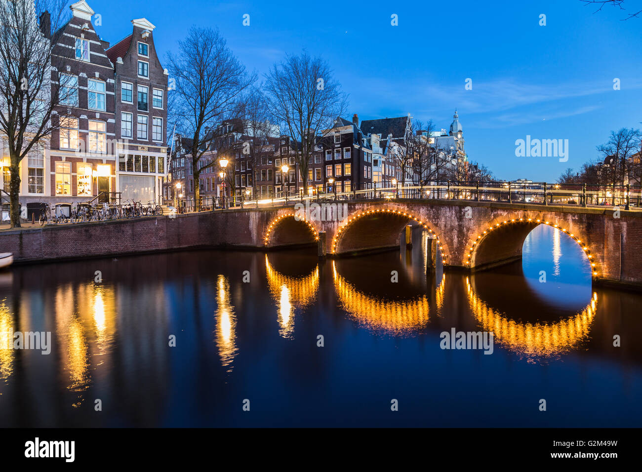 Una vista dei ponti a Leidsegracht e Keizersgracht intersezione dei canali di Amsterdam al crepuscolo. Le biciclette e gli edifici possono essere Foto Stock