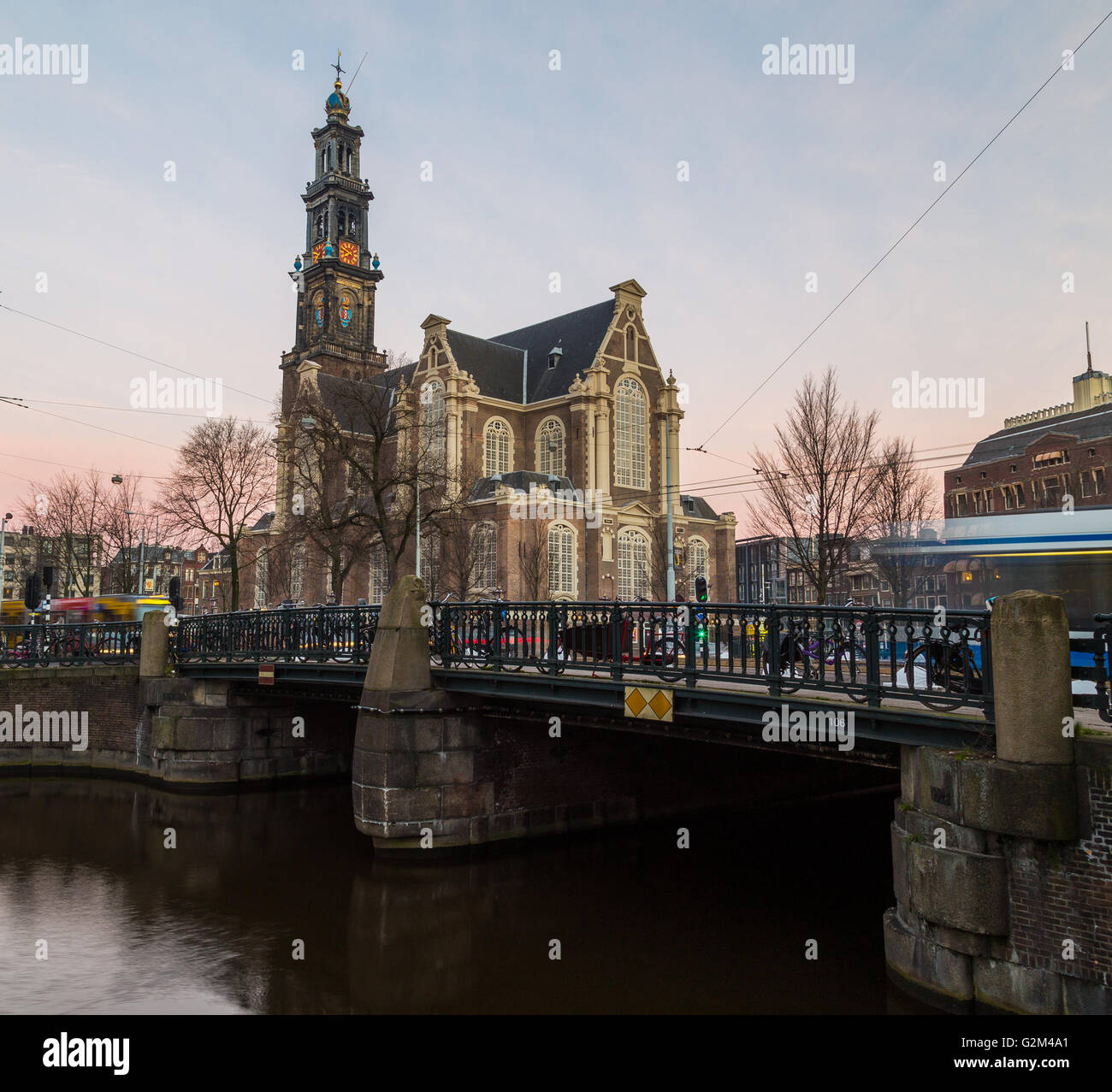 L'esterno della chiesa Westerkerk ad Amsterdam a sunrise. La sfocatura del traffico può essere visto andare passato Foto Stock