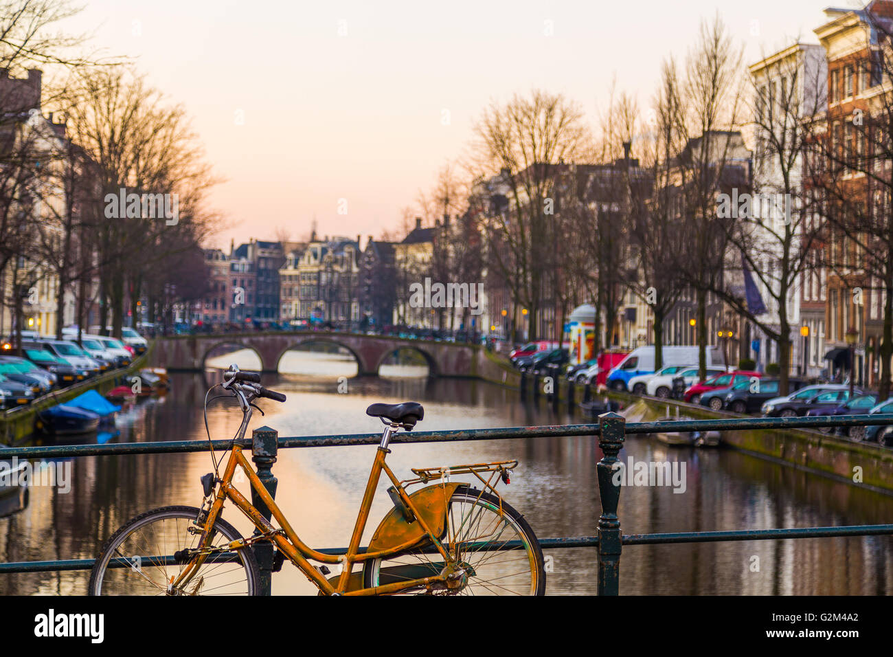 Le moto e gli edifici lungo i canali di Amsterdam a sunrise Foto Stock