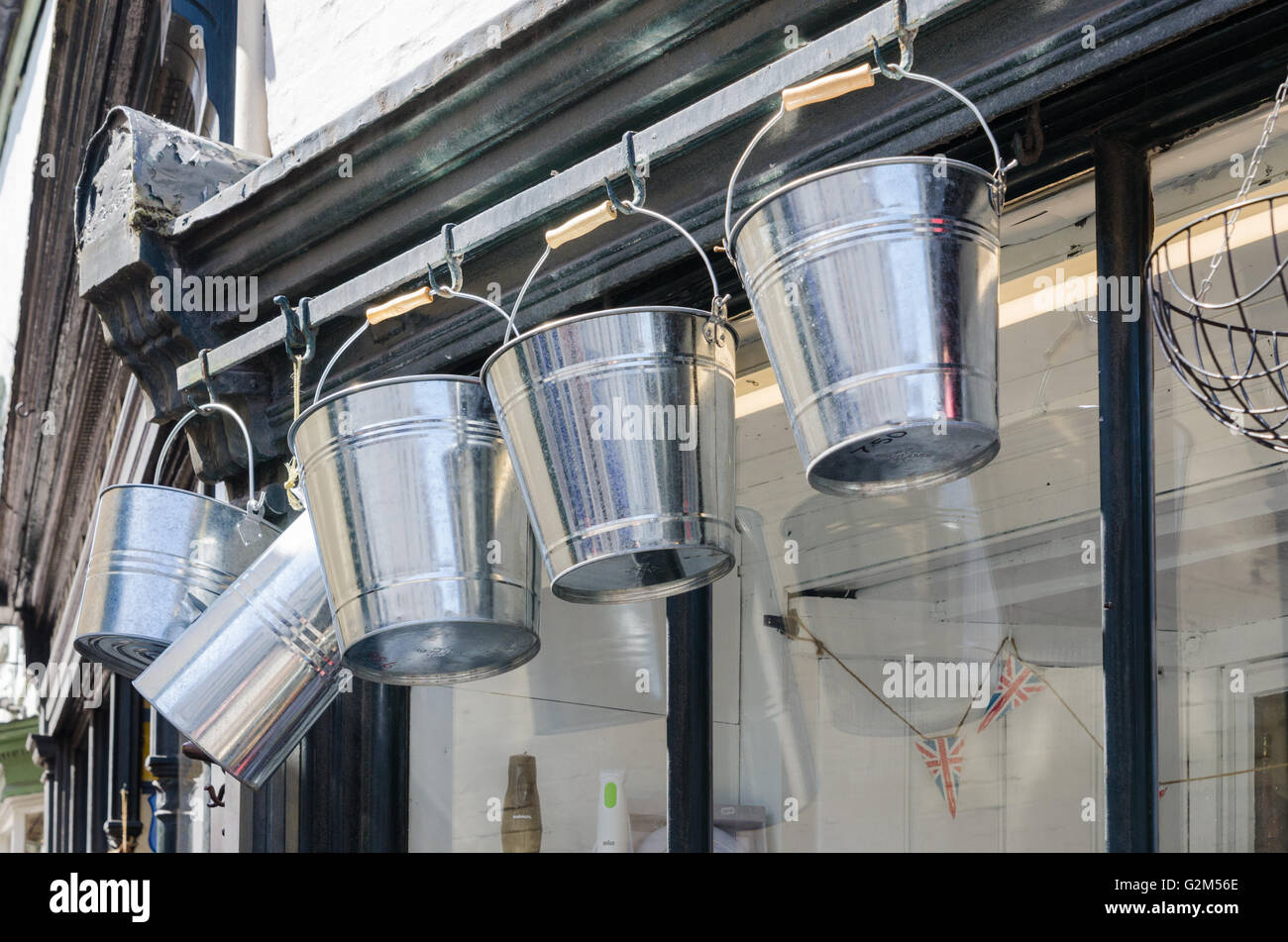 Le benne di metallo appeso al di fuori di un tradizionale hardware shop a Ludlow, Shropshire Foto Stock