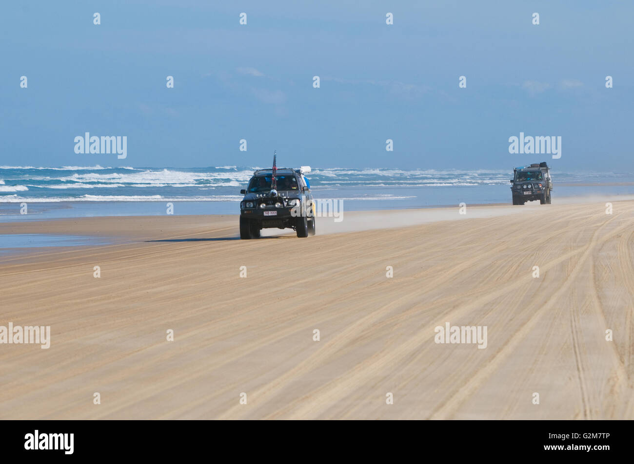 Cars driving su Fraser Island's 75 Mile Beach. Le norme della strada applica. Foto Stock
