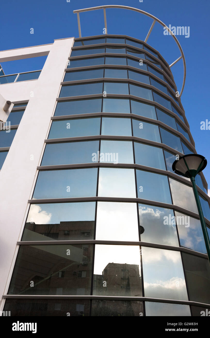 Rotondo in vetro ufficio edificio esterno con cielo blu in background Foto Stock