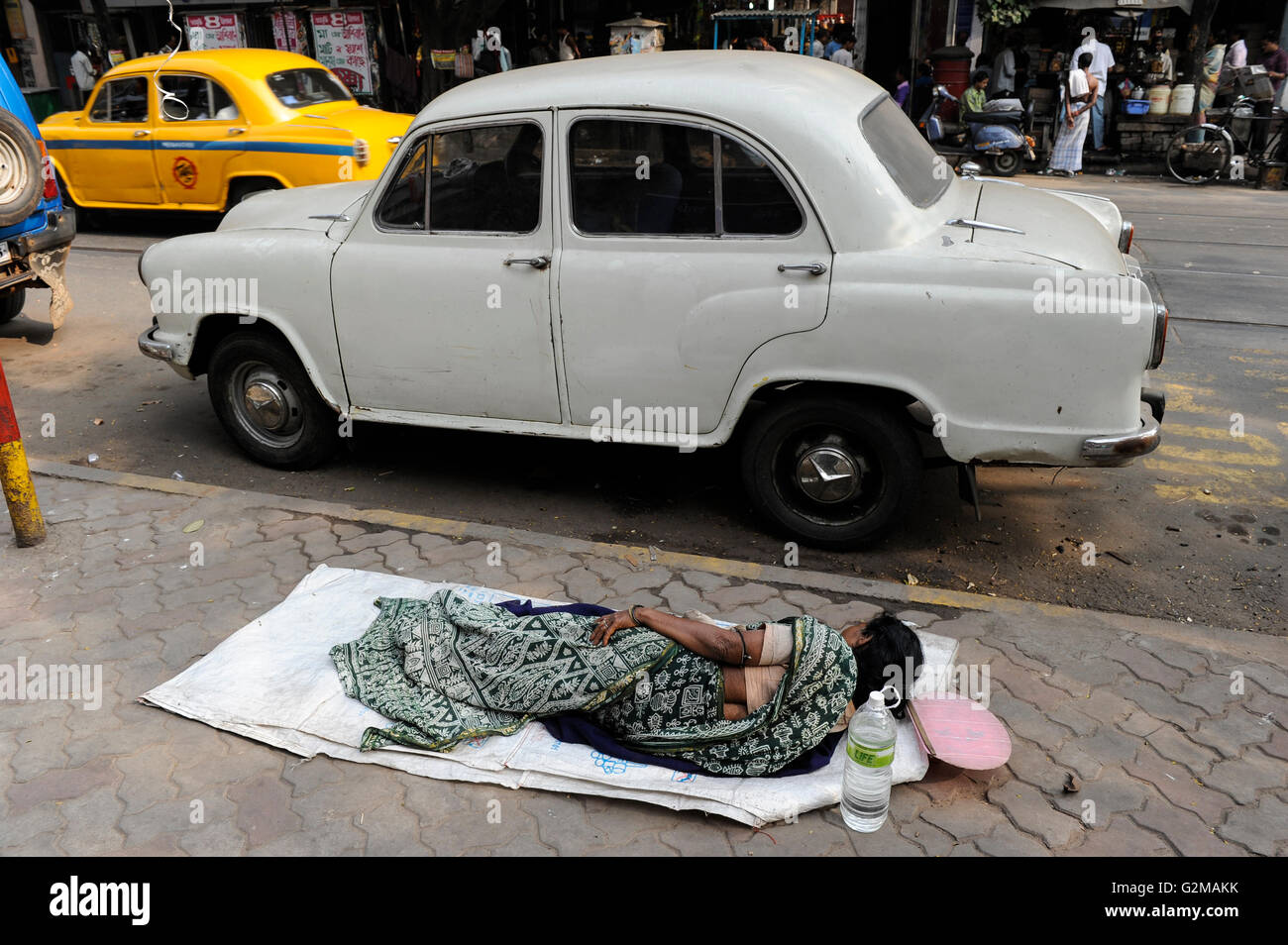 INDIA Westbengal, Calcutta, senzatetto dormire sulla strada, parcheggio HM Ambassador auto Foto Stock