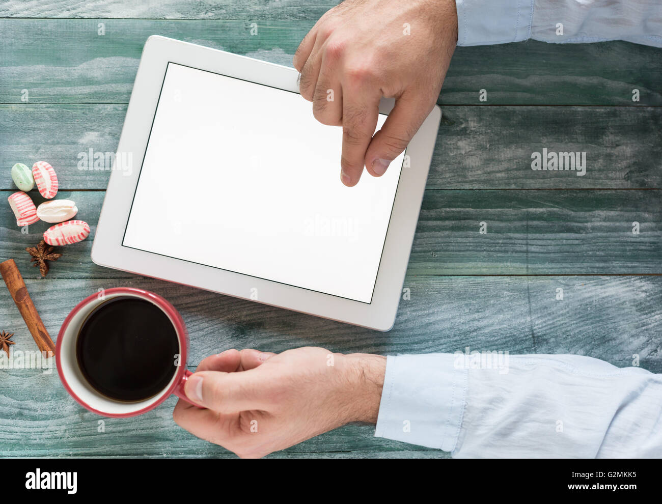 Mano con mockup tablet simile a uno stile di ipad sulla scrivania in legno display bianco con percorso di clipping semplice schermata Aggiungi immagine Foto Stock