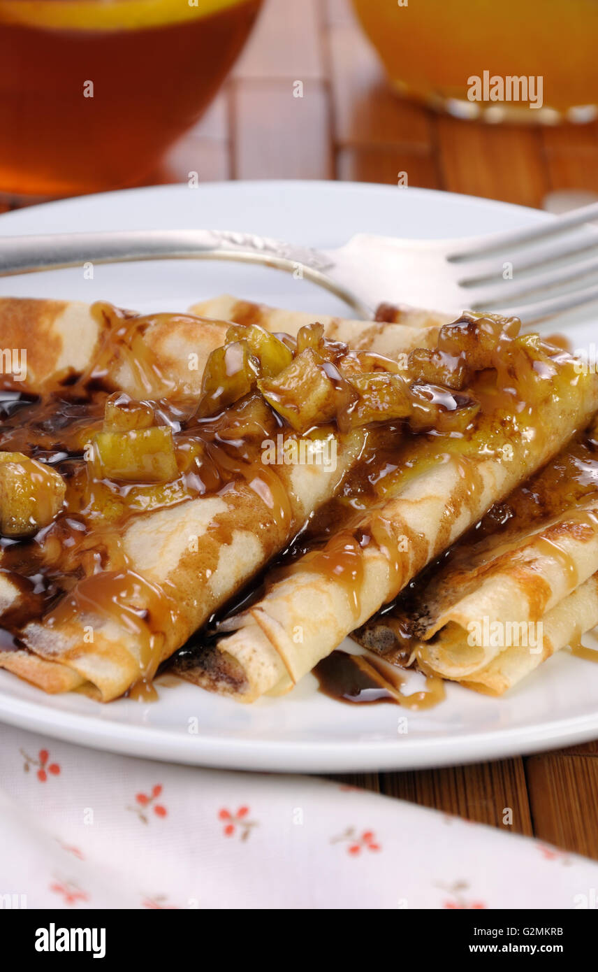 La colazione le frittelle su mele con caramello e cioccolato e la tazza di tè Foto Stock