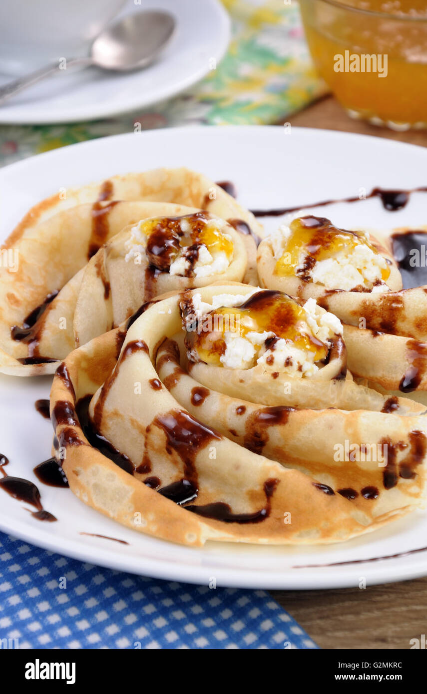 Pancake piegato nella forma di una lumaca per la ricotta con il cioccolato Foto Stock