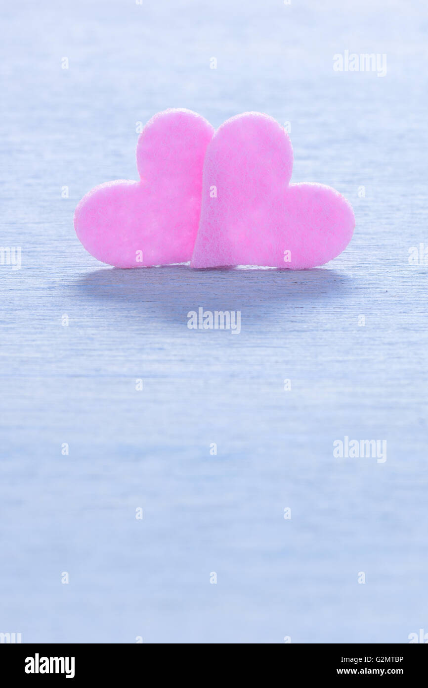 Sfondo di San Valentino con due cuori rosa su uno sfondo di legno e copia di spazio. Concetto di amore. Foto Stock