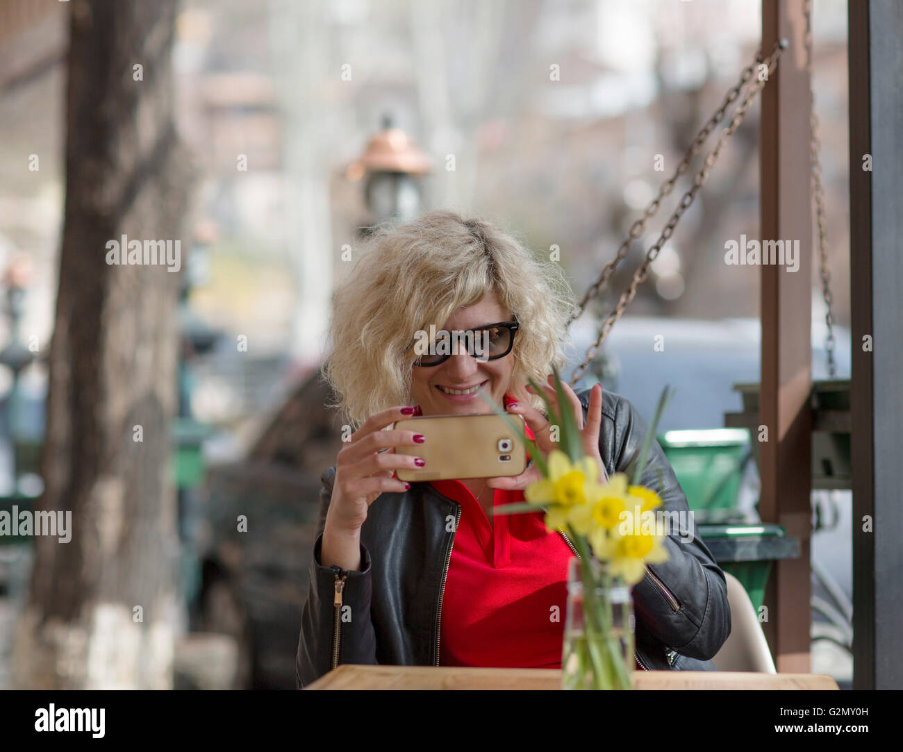 Bella ragazza bionda sorride mentre si effettua la foto sul telefono Foto Stock
