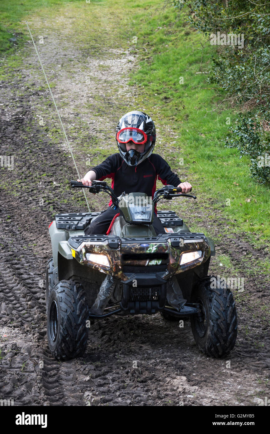 Ragazzo giovane su di una moto quad in un campo nella campagna inglese Foto Stock