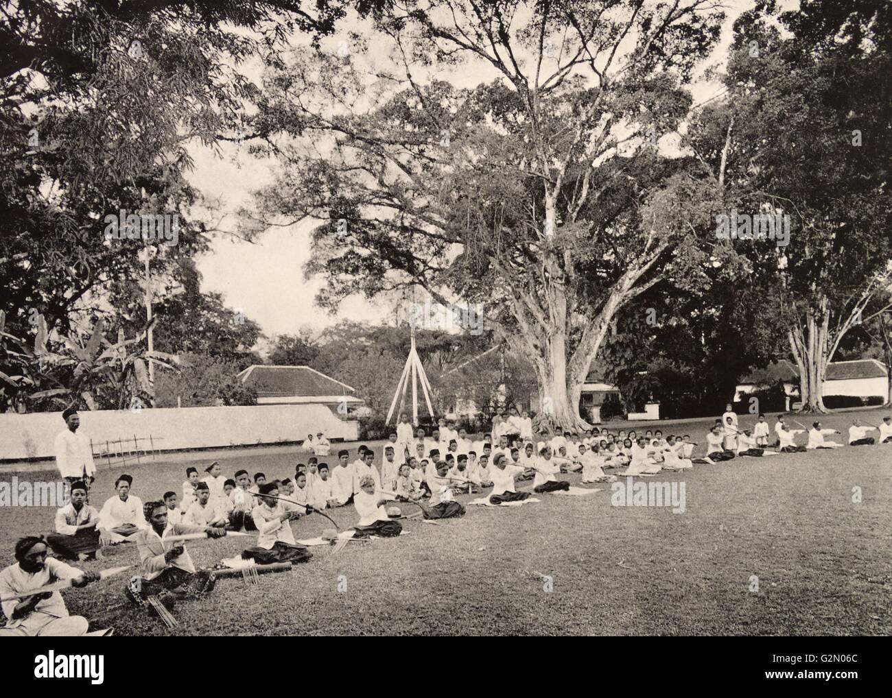 La fotografia mostra un gruppo di abitanti di essere insegnato come la caccia con arco e frecce. Le Indie orientali olandesi, noto come Indonesia moderna. Datata c1935. Foto Stock