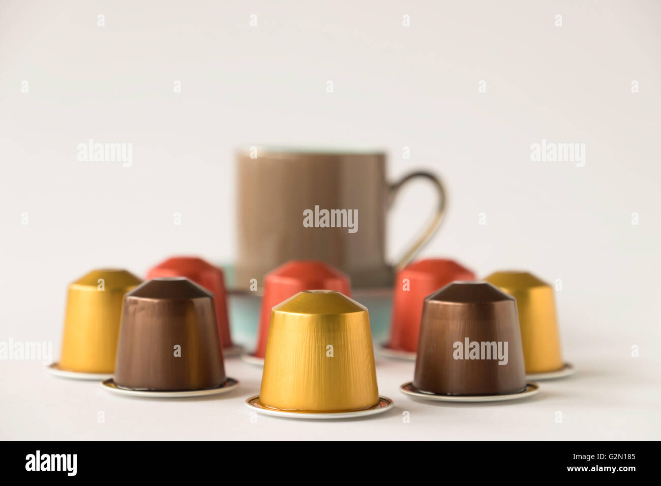 Selezione di cialde di caffè con fuori fuoco tazzina su sfondo bianco Foto Stock