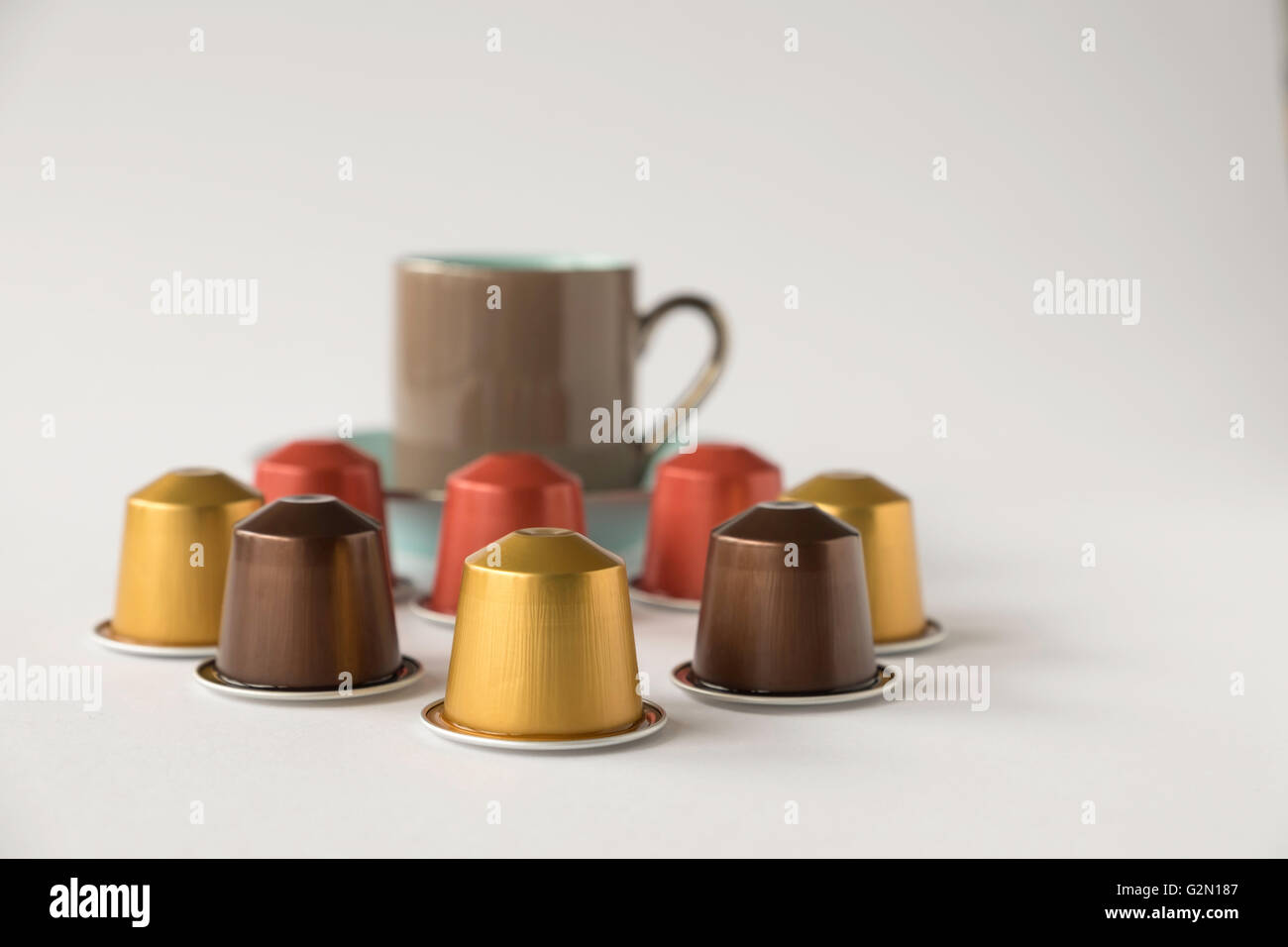 Varietà di cialde di caffè con fuori fuoco tazzina contro uno sfondo bianco Foto Stock