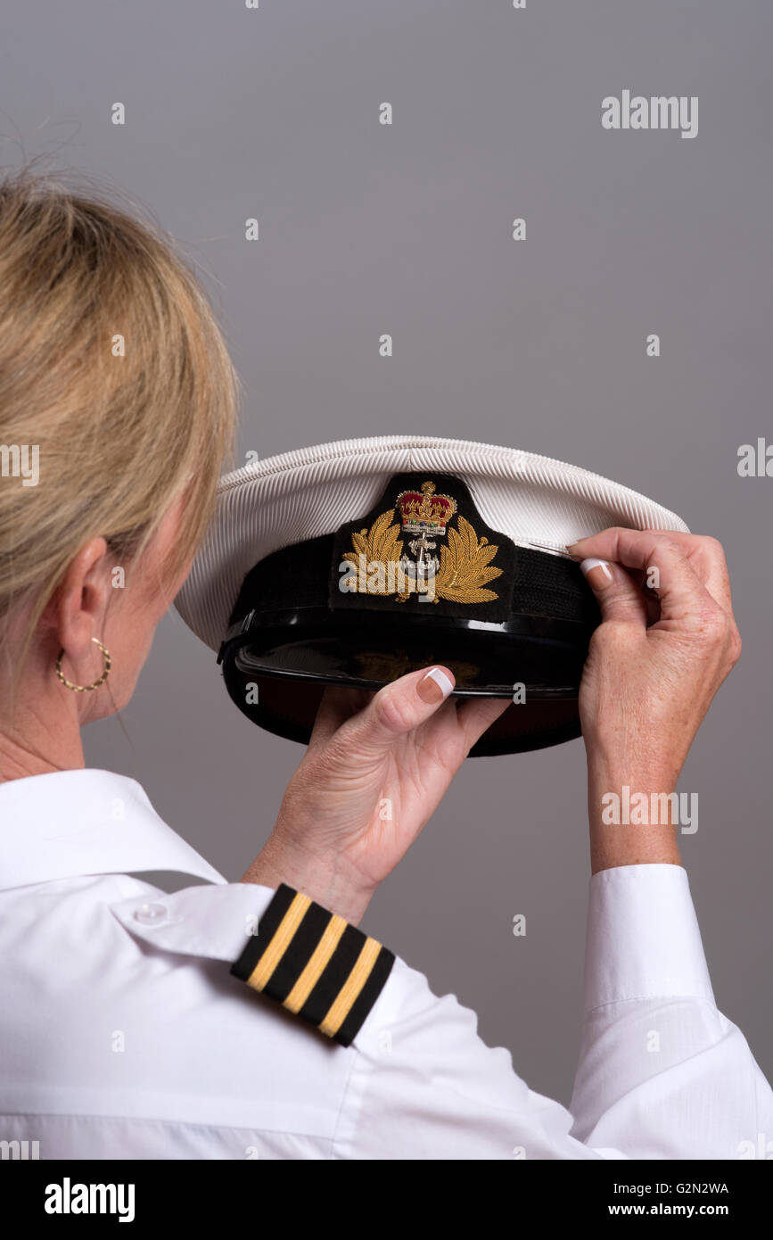 La cucitura di un cappuccio navale il BADGE SU UN Cappello ufficiale femmina cucire il cappuccio sul badge ufficiale di marina uniformi della PAC Foto Stock