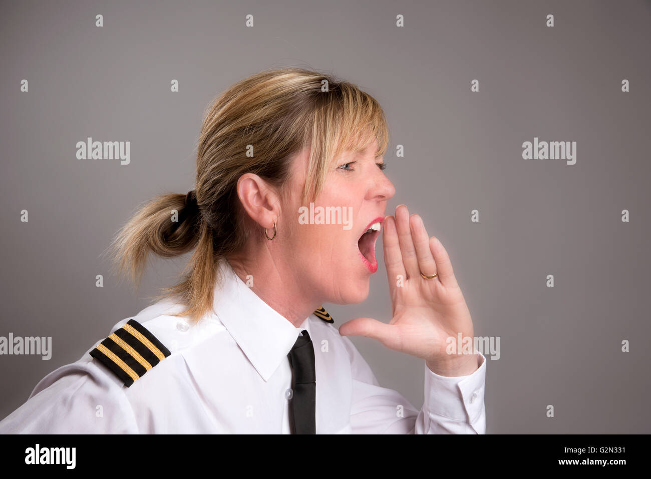 OFFICER URLA UN ORDINE Ritratto di una donna uniformata officer gridando e ordine Foto Stock