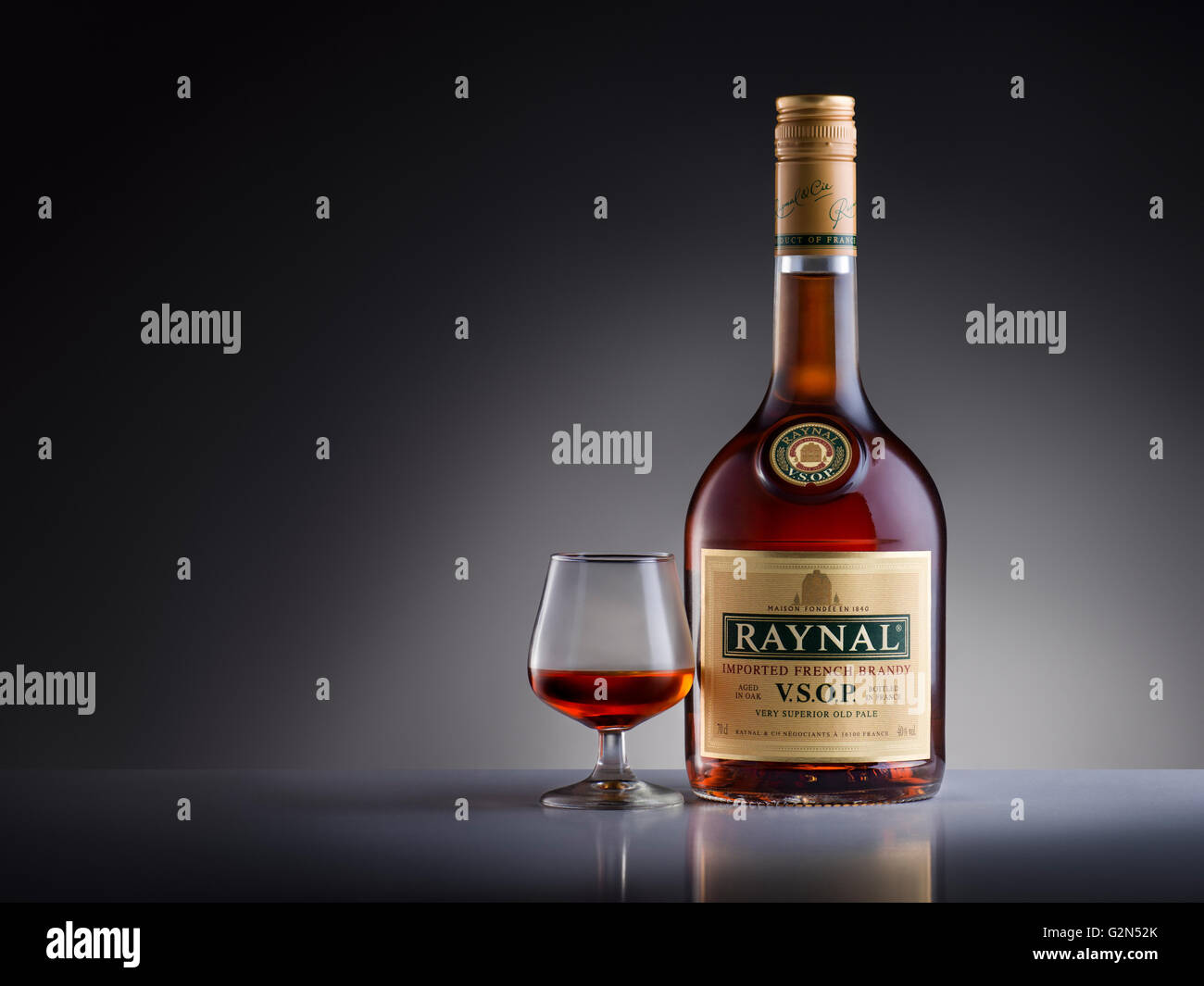 Foto di studio della bottiglia con un bicchiere di brandy Raynal. Foto Stock